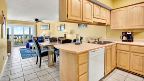 A kitchen with wooden cabinets, a dishwasher, and a coffee maker. - Mid beach ocean front 3 bedroom 2 bath condo (Tybee Island)
