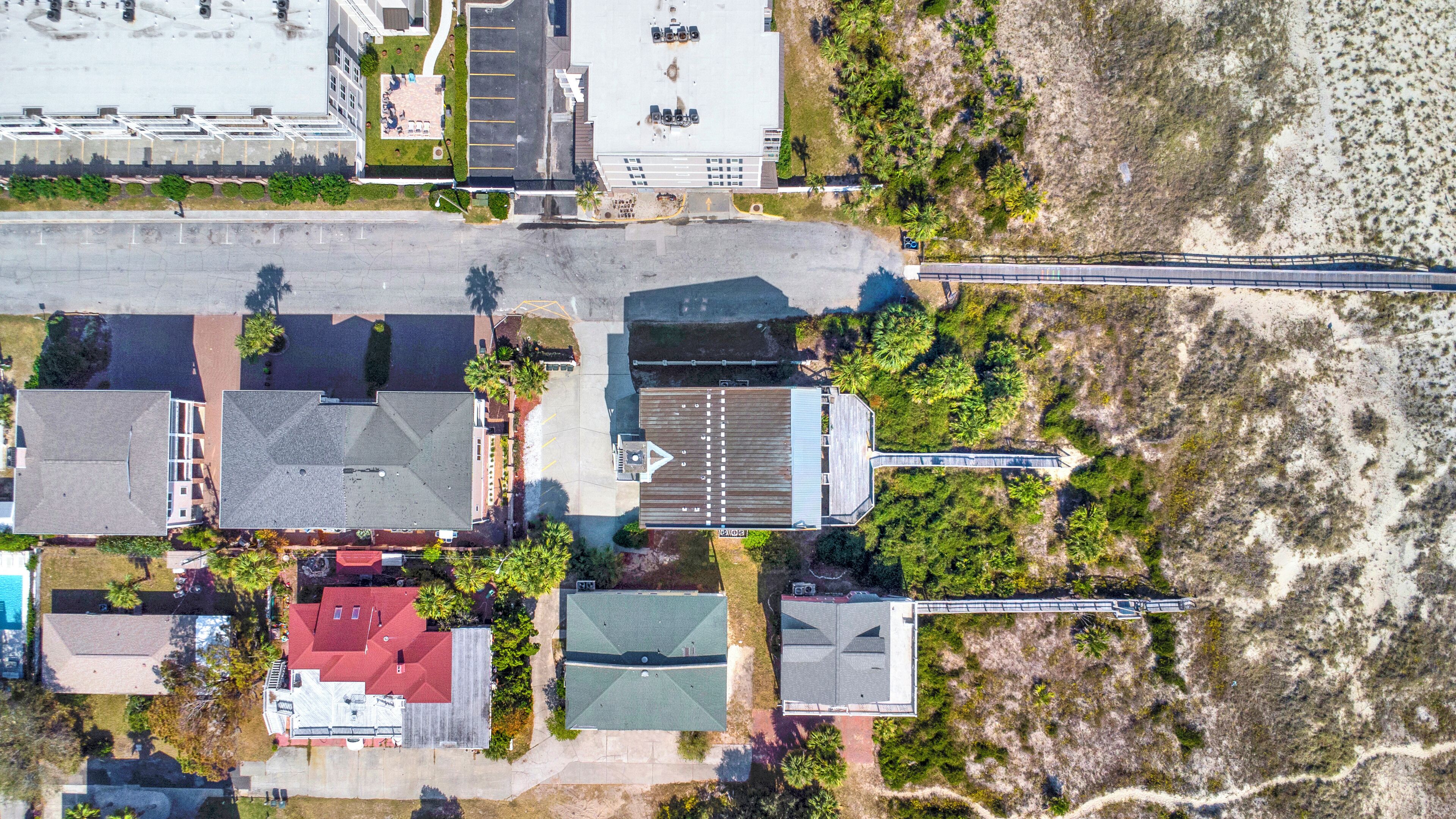 Vista aerea di una zona residenziale costiera con case, un parcheggio e una spiaggia.