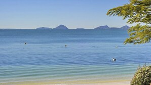 A calm sea with clear skies and distant mountains.