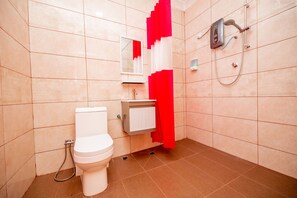 A bathroom with a toilet, sink, and shower.