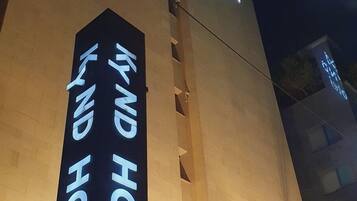 The exterior of the KYND hotel with illuminated signage.