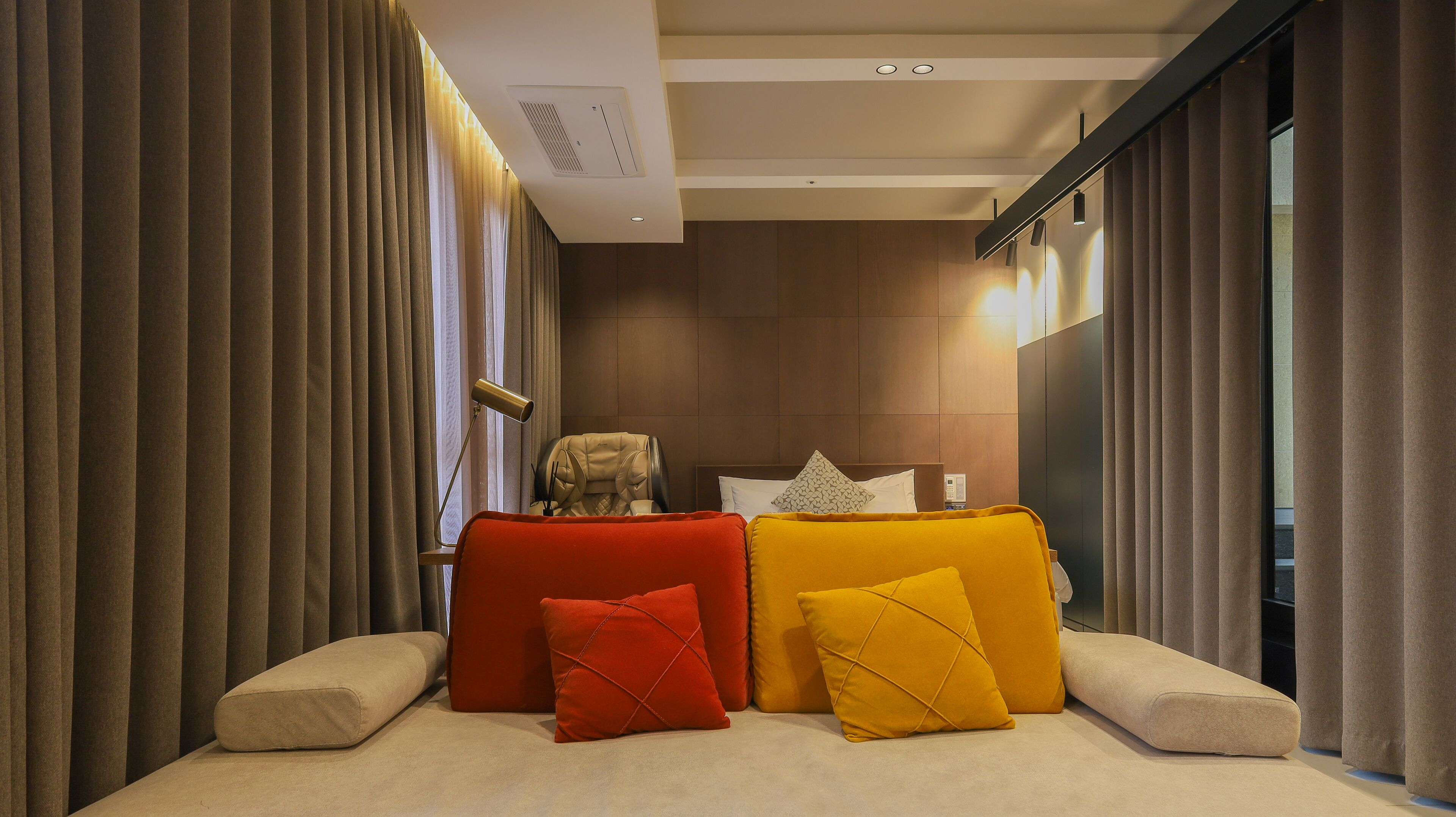 A modern hotel room with a bed, a chair, and a desk.
