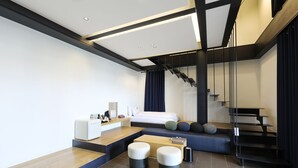 Une chambre d’hôtel moderne équipée d’un lit, d’un bureau, d’une chaise et d’un escalier.