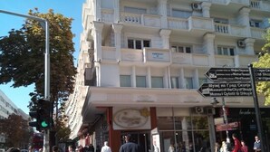 A multi-story building with a classical architectural style, featuring balconies and a prominent entrance. - TMC Skopje Apartment (Skopje)