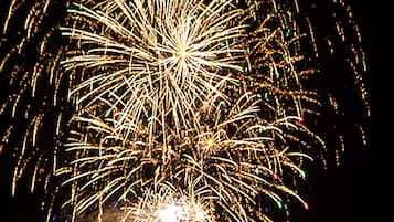 Espectacular exhibición de fuegos artificiales con múltiples explosiones y estelas sobre un cielo oscuro.