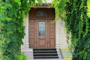 A wooden door with a glass panel and a sign above it. - Boulevard Palace (Samarkand)