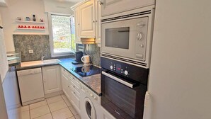 A compact kitchen with a Bosch washing machine, a coffee maker, and a built-in oven. - Apartment for 4/6 people - Swimming pool - Air conditioning - WiFi - Near center - Sainte Maxime... (STE MAXIME)