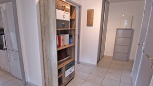 A hallway with a wooden storage unit, a refrigerator, and a door leading to another room. - Apartment for 4/6 people - Swimming pool - Air conditioning - WiFi - Near center - Sainte Maxime... (STE MAXIME)