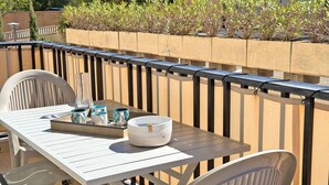 A patio with a white table and chairs, a tray with mugs and a glass, and a planter with small shrubs. - Apartment for 4/6 people - Swimming pool - Air conditioning - WiFi - Near center - Sainte Maxime... (STE MAXIME)