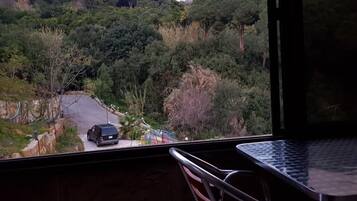A balcony with a view of a road and trees.
