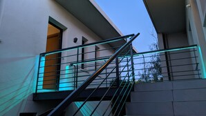 Un escalier moderne avec des rampes en métal et un éclairage à DEL bleues.
