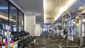 Une salle de sport équipée de matériel de musculation et d’haltères.