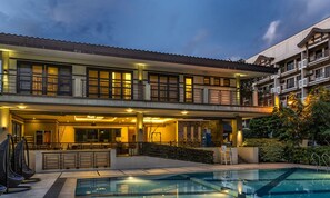 A two-story hotel with a swimming pool, outdoor seating, and a covered patio area. - The Redwoods SM Fairview with Balcony Quezon City,Metro Manila Philippines (Quezon City)