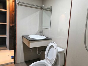 A modern bathroom with a white sink, mirror, and toilet. - Nitta Ville (Hang Chat)