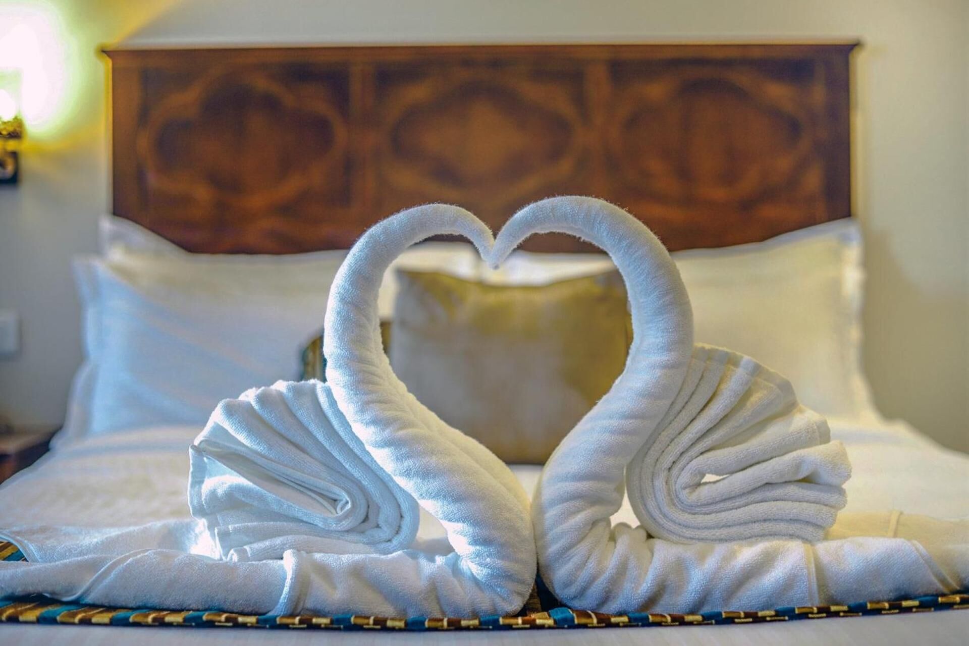 Een bed met een houten hoofdbord en witte kussens.