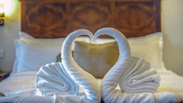 Una cama con cabecera de madera y almohadas blancas.