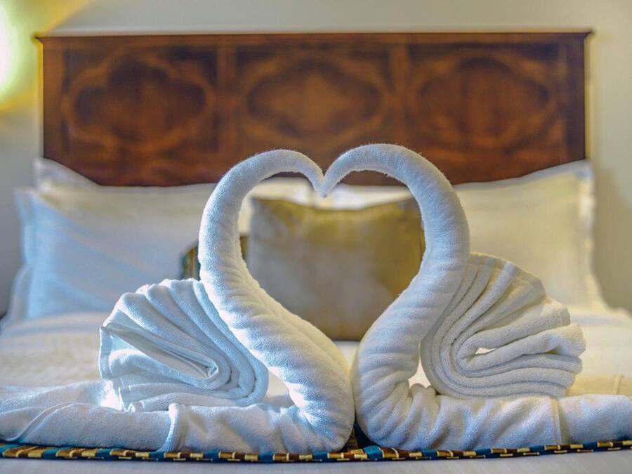 Una cama con cabecera de madera y almohadas blancas.