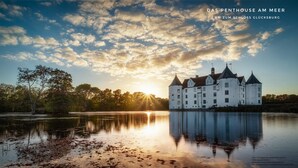 A castle with multiple towers and a moat, reflecting the sunset. - Large penthouse by the sea - box seat on the fjord - (Glücksburg (Ostsee))