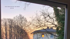 A view from a window with a vase of yellow flowers and two glass jars on a tray. - Large penthouse by the sea - box seat on the fjord - (Glücksburg (Ostsee))