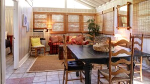 A covered dining area with a table, chairs, and a sofa. - Cute, Cozy Beach Cottage/Duplex - One block to the beach! Location is Key! (Isle of Palms)