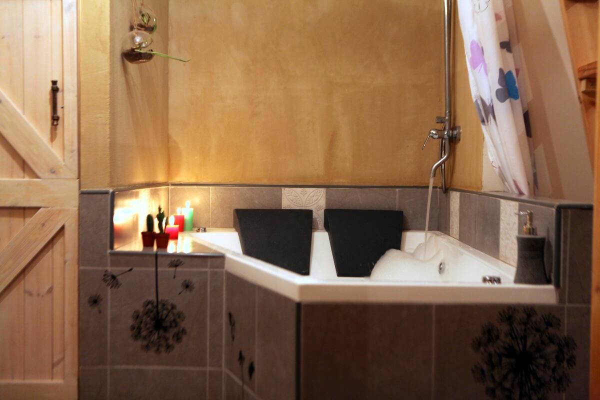 Un baño con bañera, ducha y espejo.