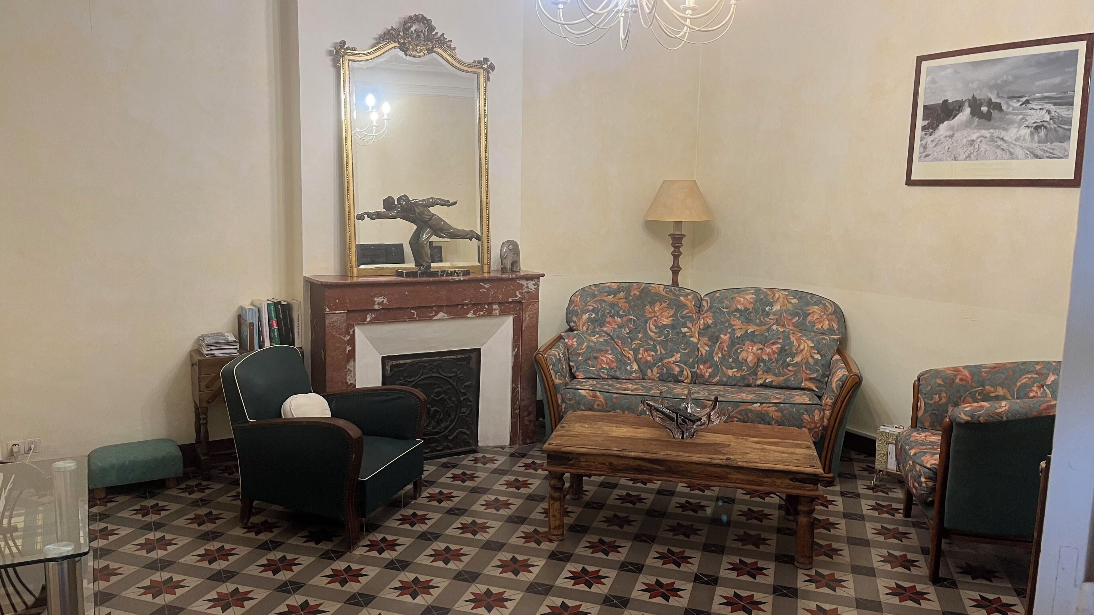 A living room with a fireplace, a sofa, a coffee table, and a chair.