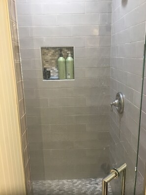 Een douche, handdoeken, zeep, toiletpapier