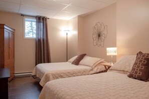 Ein Schlafzimmer mit zwei Betten, einem Kleiderschrank, einer Stehlampe und einem Wandbild.