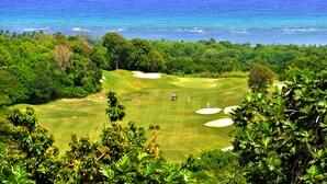 A golf course with a view of the ocean and dense tropical vegetation. - Takuma Boutique Hotel Rooms & Suites Jamaica  (Montego Bay)