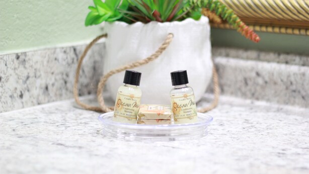 Two bottles of Ocean Mist Conditioning Shampoo on a clear glass tray. - Relax & Recharge (Kissimmee)