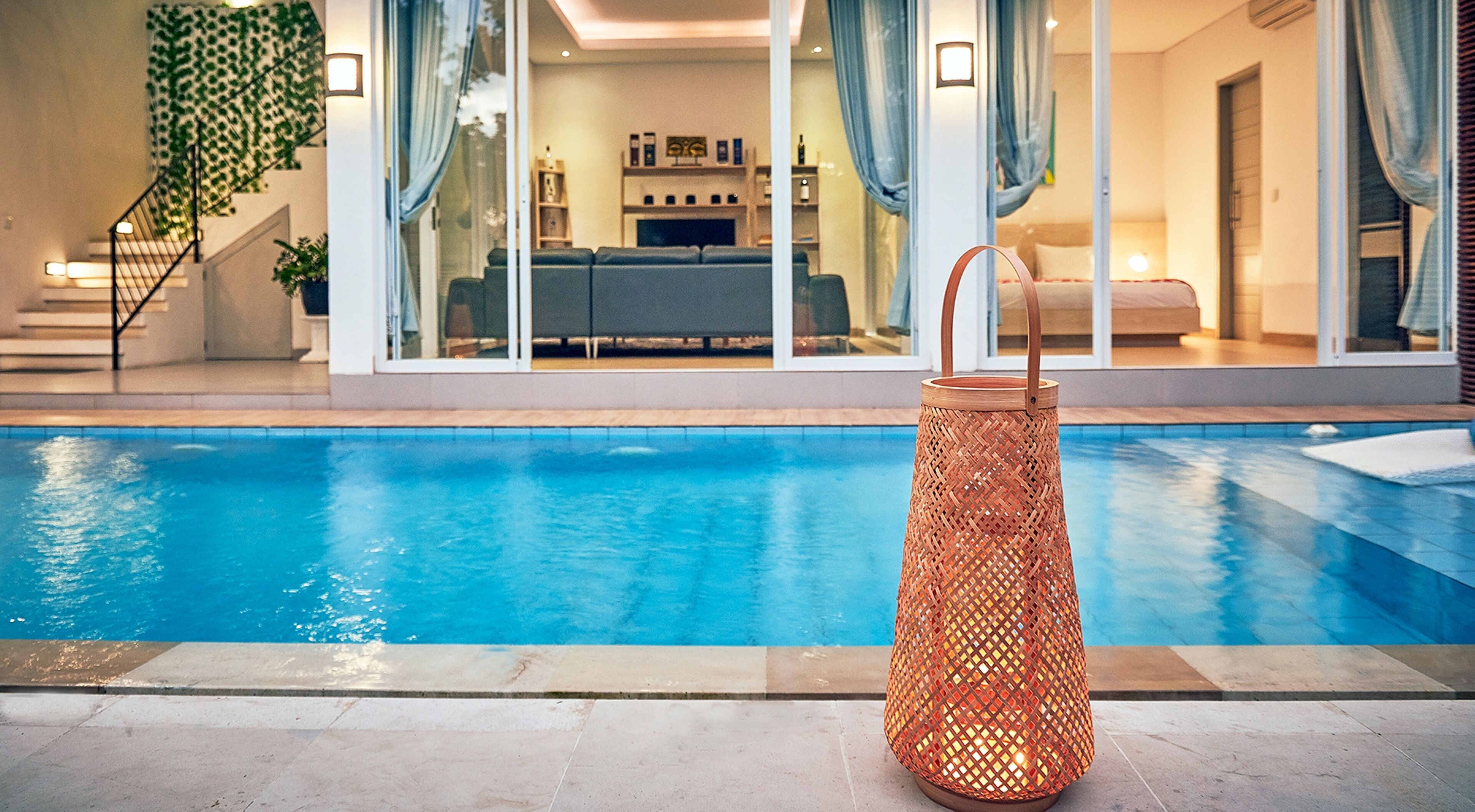 A modern pool area with a clear view of the living room in the background.