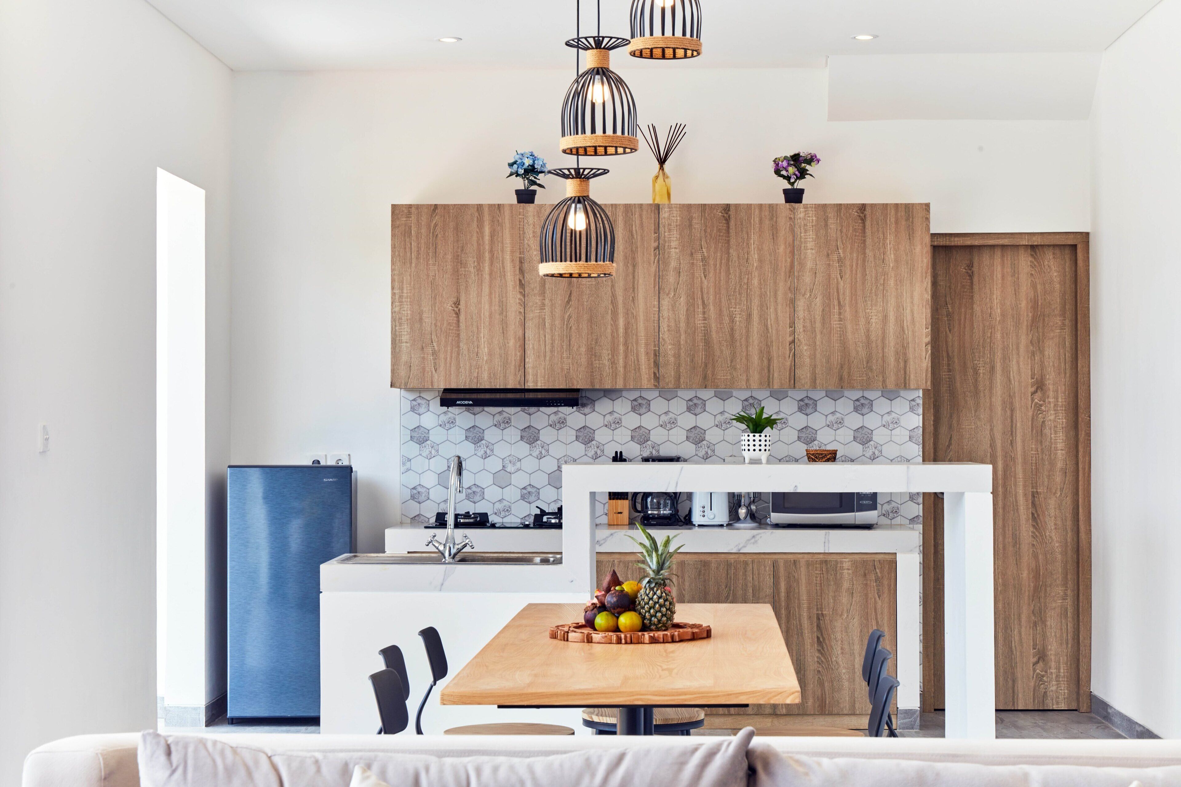 Eine moderne Küche mit Holzausstattung, einem eingebauten Backofen und einem Essbereich mit Tisch und Stühlen.