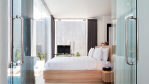 Une chambre d’hôtel moderne avec un grand lit, une télévision et une vue sur une piscine.