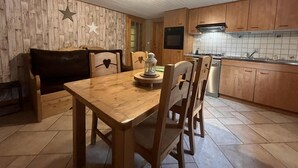 Eine gemütliche Küche mit Holzschränken, einem Esstisch und Stühlen.