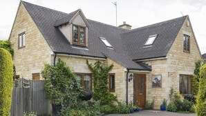 A stone house with a sloped roof, dormer windows, and a front door. - Kingfisher Cottage - sleeps 10 guests  in 5 bedrooms (Winchcombe)