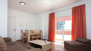 Ein modernes Wohnzimmer mit einer Couch, einem Couchtisch und einem Essbereich mit Stühlen.