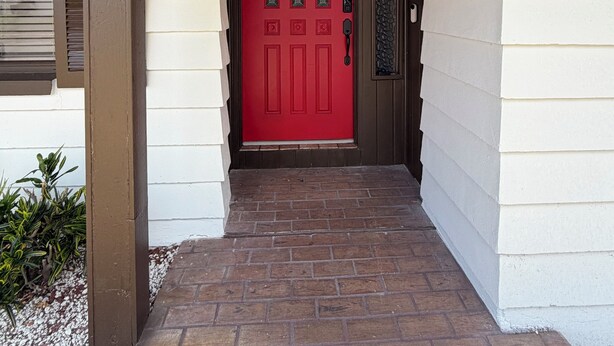 A red door with a mailbox, a number '1940' sign, and a lantern on the porch. - The Oasis Private Pool Home + Best Launch Views! No cleaning fee. (Titusville)