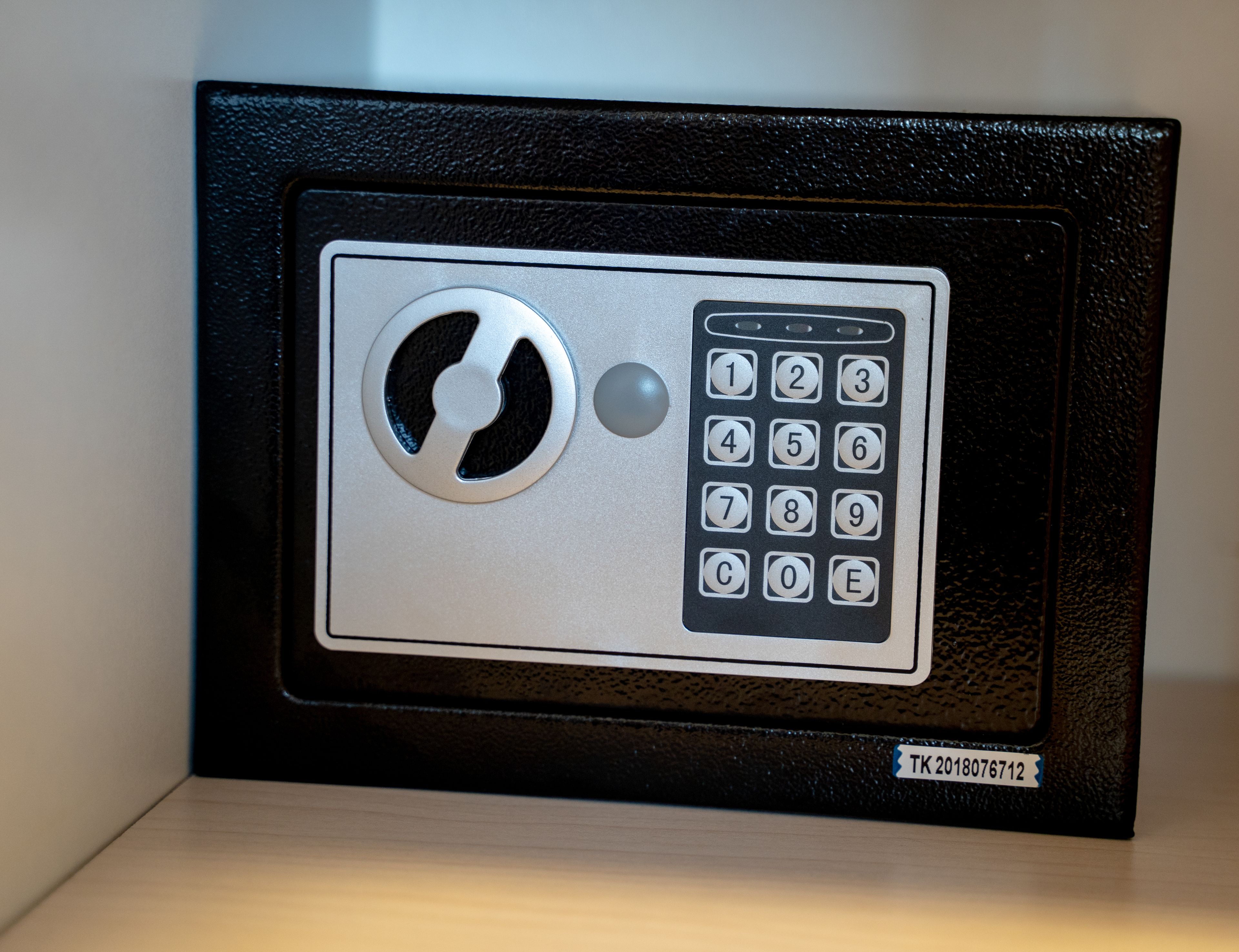 A keypad lock with a keyhole and a label with a code.