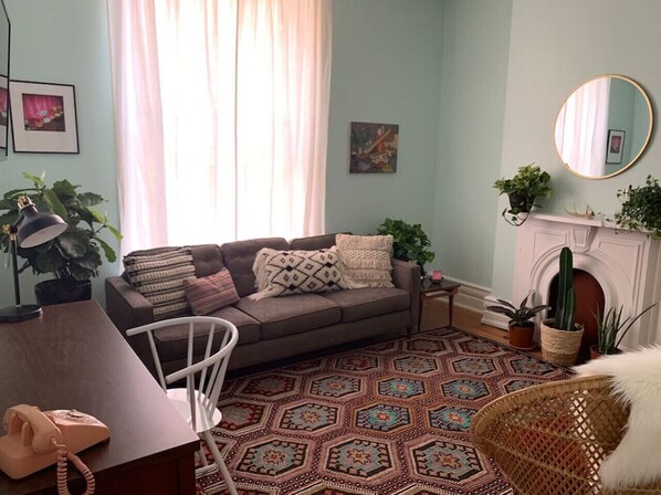 Ein Wohnzimmer mit einer Couch, einem gemusterten Teppich und einem Kamin.