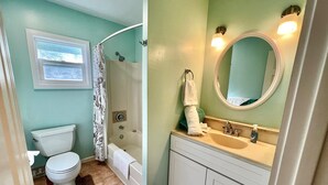 A bathroom with a toilet, shower, and sink.