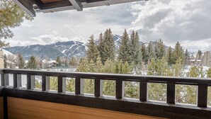 Ein Balkon mit Blick auf schneebedeckte Berge und immergrüne Bäume.