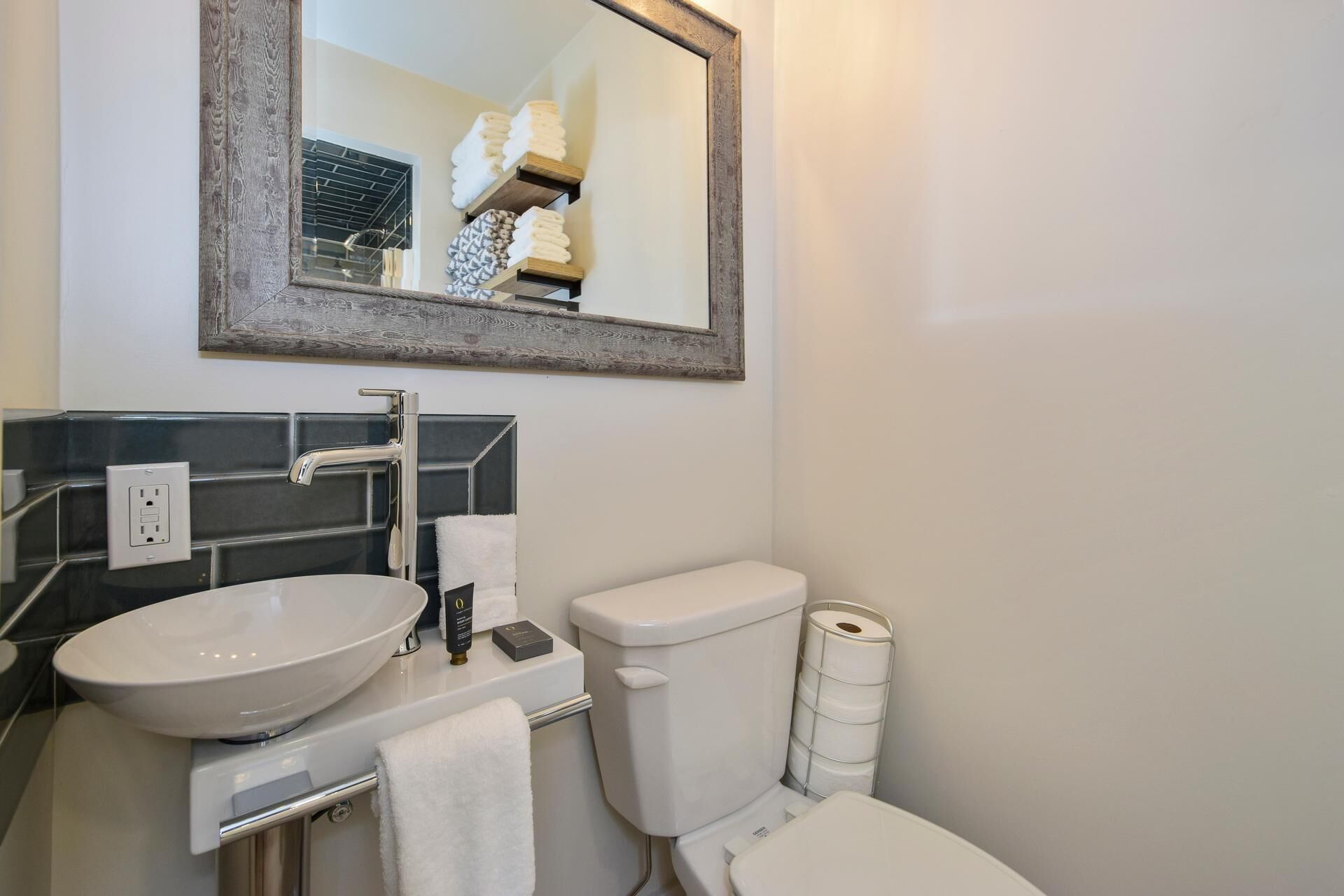 A bathroom with a white sink, a toilet, and a mirror above the sink.