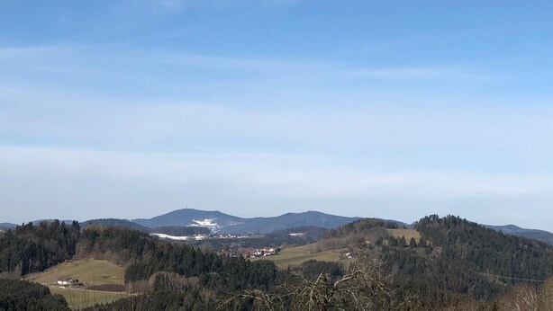 Vista panorâmica de uma paisagem montanhosa sob um céu claro.