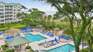 Een resort met verschillende zwembaden, ontspanningsruimtes en uitzicht op de oceaan.