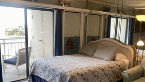 Un dormitorio con cama, ventilador de techo, ventana y puerta.