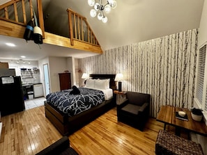 Cozy retreat with a bed, seating area, and kitchenette, perfect for a relaxing stay.