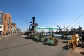 A street with outdoor seating, a sculpture, and a view of the water. - Crow's Nest - Directly on Poole Quay (Poole)