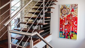 Eine moderne Treppe mit Metallgeländern und Holzboden, die zu einer oberen Etage führt.
