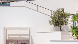 Ein moderner Poolbereich mit einer weißen Bank und einem kleinen Baum.