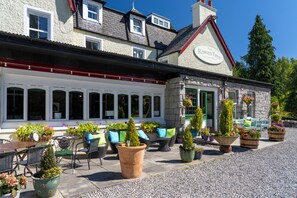 A country hotel with outdoor seating and potted plants. - Rowan Tree Country Hotel (Aviemore)